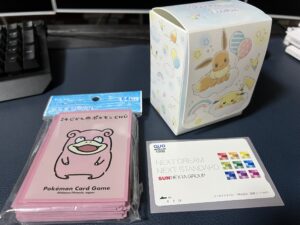 サンネクスタグループ（8945）の株主優待QUOカードをポケモンカード用デッキシールドで保護し、デッキケースで保管している様子